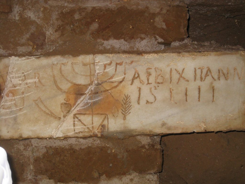 Ancient writings and menora in the Catacombs